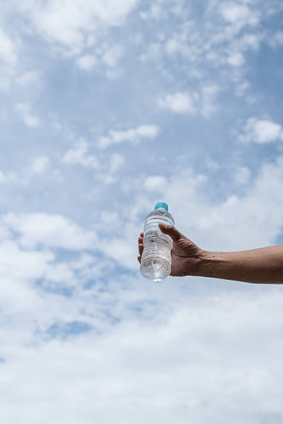 istock Person holding a plastic bottle of water 2228245269