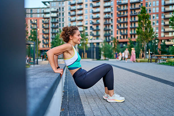 istock Woman exercising using a low wall as support in a city park 2228249876
