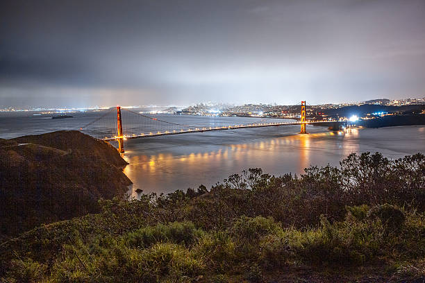 Experience the breathtaking sunset over the Golden Gate Bridge in San Francisco, California, with city lights reflecting on the bay. This iconic landmark offers a stunning view of the illuminated suspension bridge, vibrant sky, and scenic waterfront.