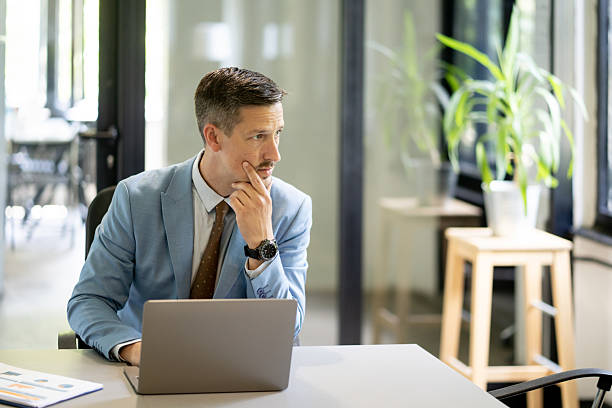 istock Pensive businessman thinking about a solution at his desk in the office 2228253742