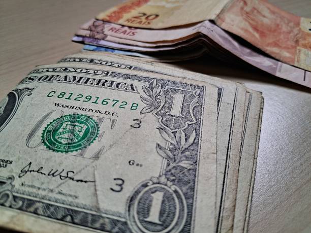istock Dollar and real bills on a light wooden table 2228255647