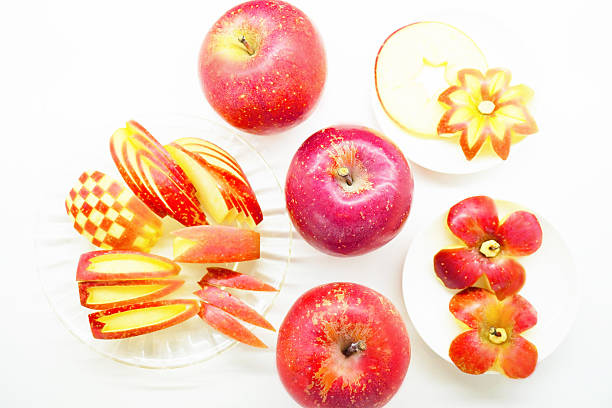 Small plate with sliced apple on red table in the sun. High quality photo