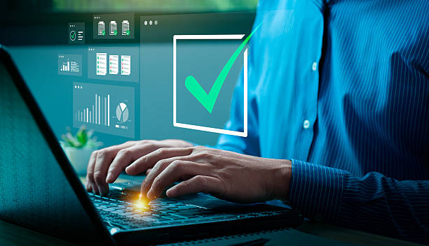 istock Businessman typing on laptop with virtual check mark and data analytics icons, representing task completion, digital approval process, project management, performance monitoring, and business success 2228267253