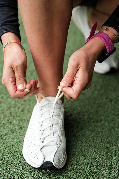 istock Female athlete tying shoelaces on white sneakers before workout 2228269991