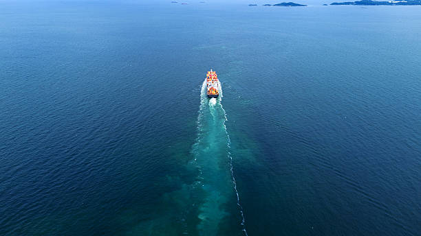 istock Aerial of cargo ship carrying container and running verry fast for export cargo from cargo yard port to other ocean concept smart freight shipping ship stern view 2228273211
