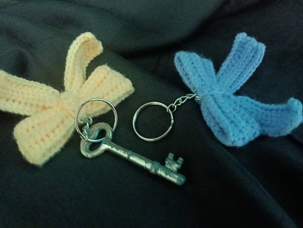 istock Handmade Crochet Keychains with Bow Designs and a key on Dark Fabric Background 2228273754