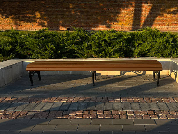 istock Unoccupied wooden bench outdoors. Public space concept. Handheld mobile photo, selective focus, sunset sunlight, non AI 2228274518