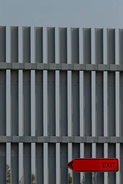istock A wooden fence that has a bright red exit sign indicating the right direction 2228280612