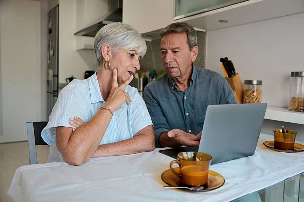 istock Senior couple using laptop and discussing in kitchen 2228284549