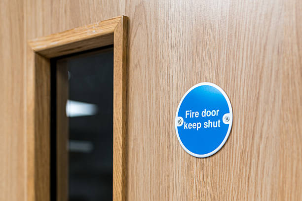 Close-up of a typical Fire Door Keep Shut sign seen on an interior door within a British hospital. stock photo