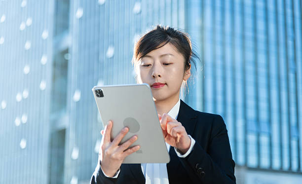 istock Businesswoman using digital tablet outside the office building 2228288721