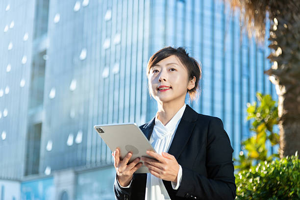 istock Businesswoman using digital tablet outside the office building 2228288725