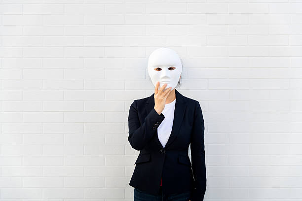 Woman hiding her face behind a white mask