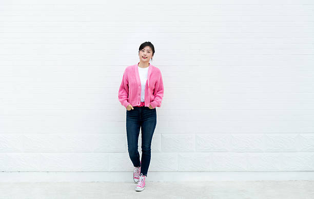istock Smiling woman standing with hands in pockets 2228289555