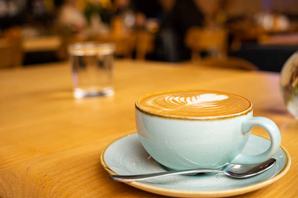 istock Cappuccino in pastel blue cup with latte art on cafe table 2228293180