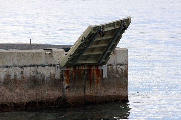 istock Concrete waterfront dock with elevated aluminum boat ramp and rusty tidal stains 2228299346