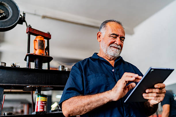 istock Senior mechanic man using digital tablet at auto repair shop 2228302299