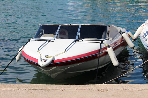 istock Small motorboat moored at dock with protective fenders 2228302651