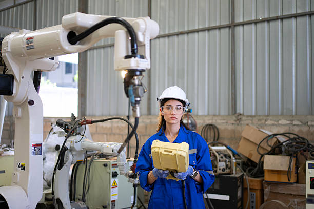istock Blue collar worker is working at machine shop with welding robot arm. 2228304406