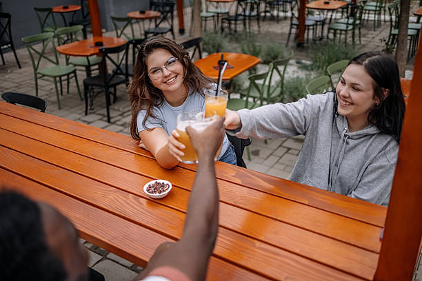 istock Group of friends having drink together at sidewalk cafe while enjoying talking and cheering with glasses 2228304730