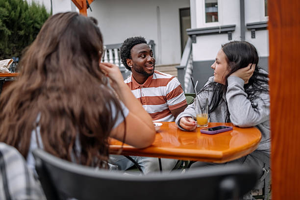 istock Group of friends having drink together at sidewalk cafe while enjoying talking 2228304858