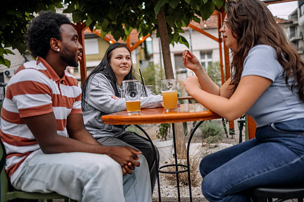 istock Group of friends having drink together at sidewalk cafe while enjoying talking 2228304866