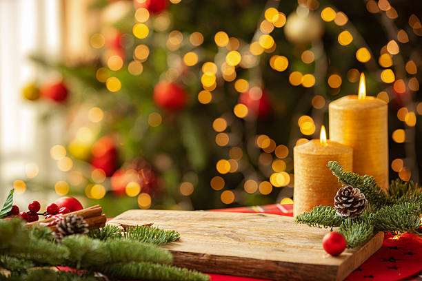 Defocused Christmas background of tree illuminated with string light and burning candles. Cozy and warm colors ideal for text placing or product montage. Seasonal or December template