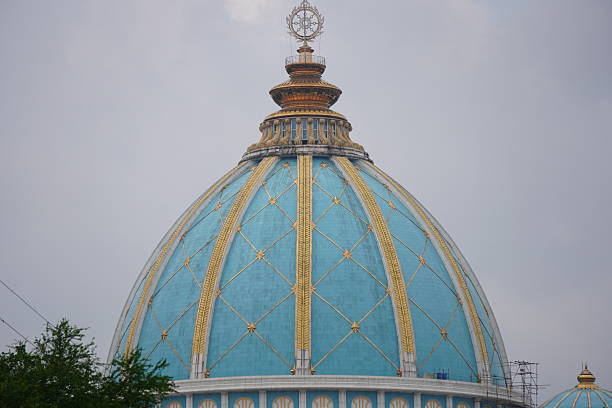 A blue dome architecture on the top of a temple, a sun motive on the top
