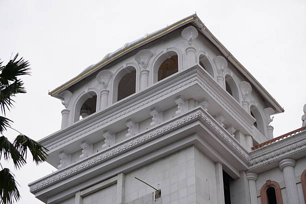 istock White Classical Building Facade with Arched Windows, Decorative Columns, and Ornate Roof Trim 2228311724
