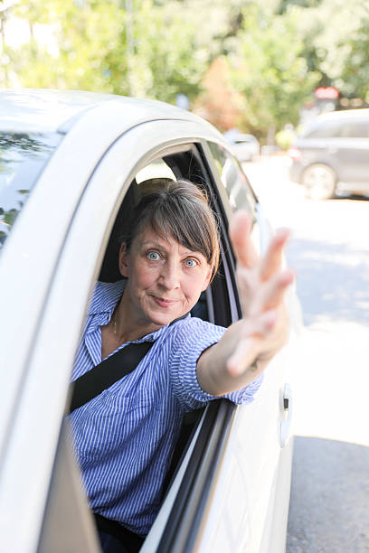 istock Female Driver Extending Hand From Car Window With Urgency 2228314066