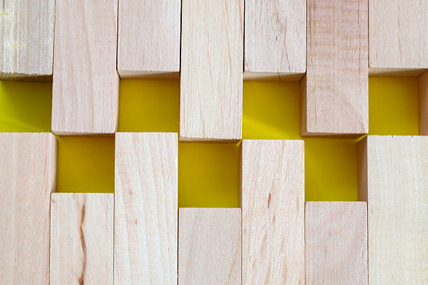 A geometric composition of light wooden blocks creating a pattern of yellow squares. This photograph is ideal for visualizing ideas related to construction, creativity, and design, as well as for use as a background for presentations and advertising materials.