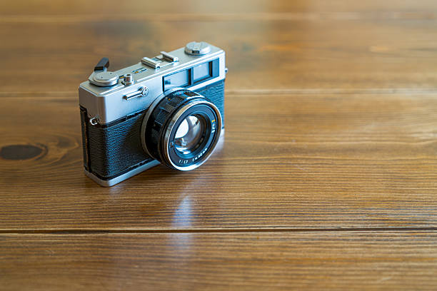 istock Old film camera isolated on wooden table 2228314608