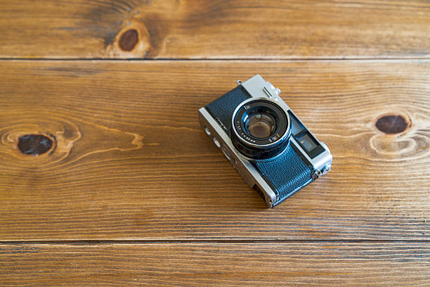 Old film camera isolated on wooden table