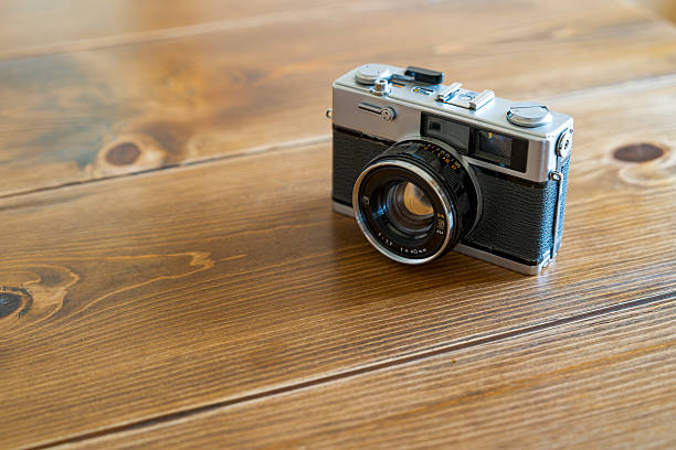 istock Old film camera isolated on wooden table 2228314662