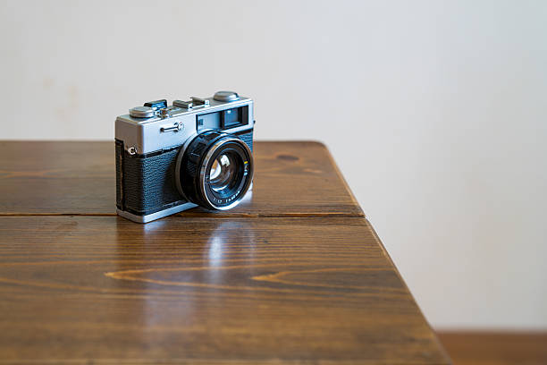 istock Old film camera isolated on wooden table 2228314698