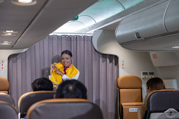 istock African flight attendant is demonstrating safety procedure using life jacket before taking off in the airplane for cabin crew and airline business 2228317307
