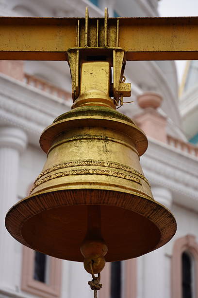 Close-up of a brass pooja bell in use during a pooja during a South Indian Hindu wedding ceremony.