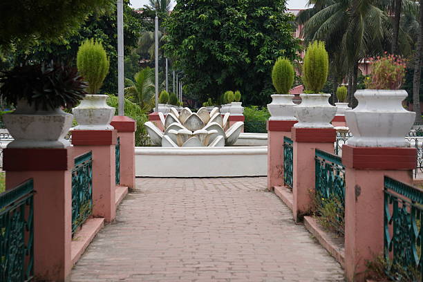A pathway leading to a decorative fountain within a temple complex or a well-maintained garden area