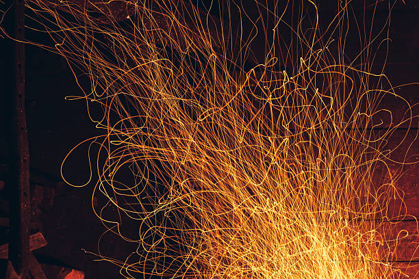 Yellow fire sparks is flying. Beautiful abstract background. Christmas evening at the fireplace. Art trail of firework. Burning trace glowing over black background. Natural pattern with copy space.