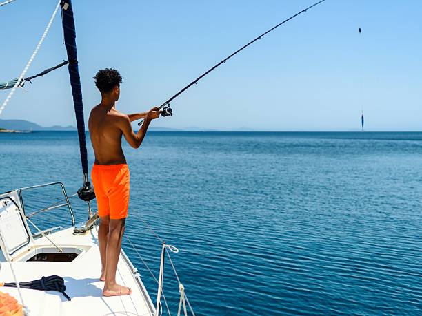 A young man fishing on a boat