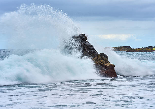istock Waves crashing on volcanic rock 2228334406