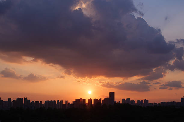 Captured in Wuhan during a warm August evening around 7 PM, this photo features vibrant orange clouds and a soft gradient sky at sunset. The dramatic cloudscape and peaceful summer atmosphere evoke serenity, making it ideal for nature, weather, or seasonal visuals.