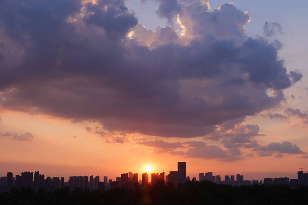 Captured in Wuhan during a warm August evening around 7 PM, this photo features vibrant orange clouds and a soft gradient sky at sunset. The dramatic cloudscape and peaceful summer atmosphere evoke serenity, making it ideal for nature, weather, or seasonal visuals.