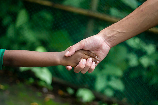 istock A black baby and a white man shaking hands together and background blur 2228334908