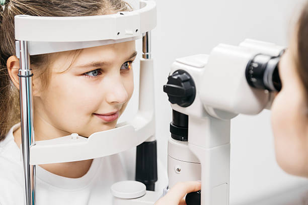 istock Young girl undergoing vision testing in an ophthalmology clinic, focusing on eye examination equipment 2228335437