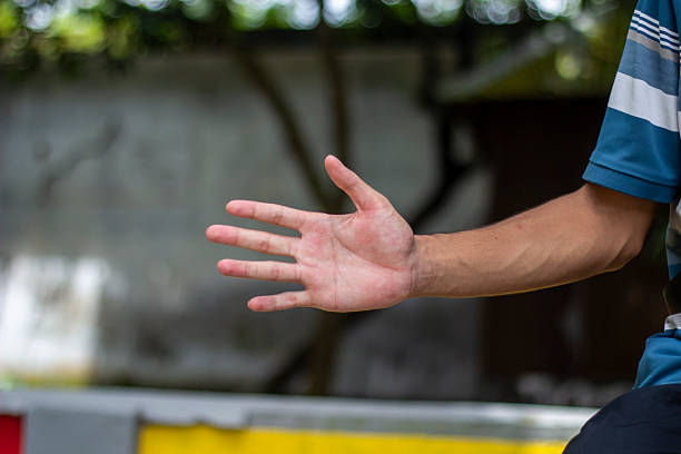 A man pointing five fingers of his hand forward and green background