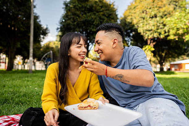 istock Young couple eating dessert during picnic on public park 2228337628