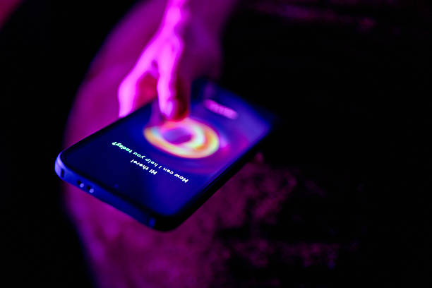 A hand interacts with an AI chatbot on a smartphone screen, glowing under dramatic purple lighting in a dark environment.
