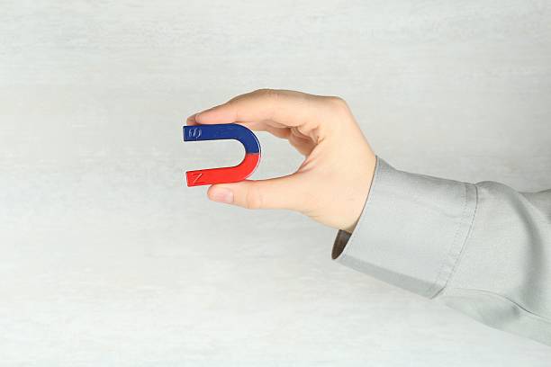 istock Woman with horseshoe magnet on light background, closeup 2228340615