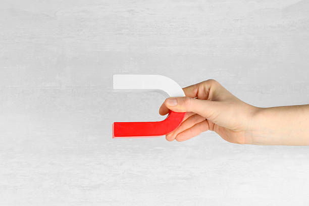 istock Woman with horseshoe magnet on light background, closeup 2228340623